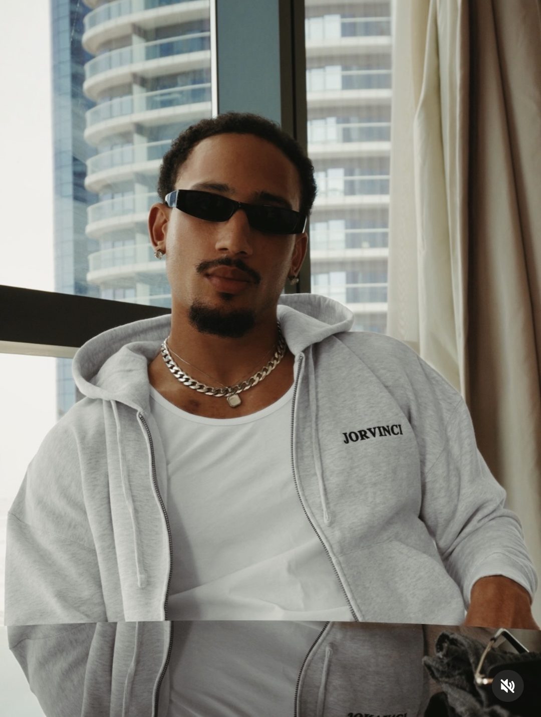 Aaron Fife style portrait in sunglasses and a grey hoodie in Dubai